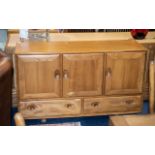 An Ercol Elm Sideboard Three Cupboard Drawers Above Two Long Drawers. Raised on Casters.