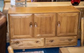 An Ercol Elm Sideboard Three Cupboard Drawers Above Two Long Drawers. Raised on Casters.