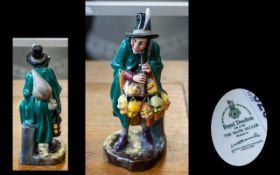 Royal Doulton 'The Mask Seller' HN 2103, 9" tall, depicting a man with masks and a flute.