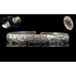 Antique Period Chinese Solid Silver Bangle Decorated With A Central Flower Design On A Hand