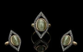 An Antique Dress Ring, set with a central pale green Cabochon, with old rose cut diamond border.