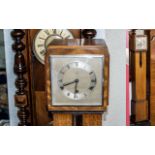 Art Deco Granddaughter Clock, teak casing, square silver face, Roman numerals. Measures 9'' wide x