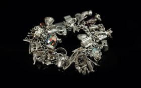 A Superb Vintage Sterling Silver Charm Bracelet, loaded with over 30 silver charms, all marked for