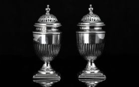 A Fine Pair of Sterling Silver Pepperettes of Classical Form, with reeded bodies, standing on