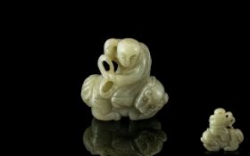 A Jade Carving of a Man riding a beast, measuring 2 inches high.