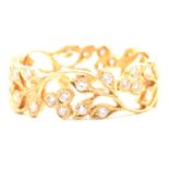 A diamond set 18 carat yellow gold filigree band.
