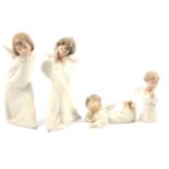 Four Lladro angel figurines.