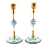 A pair of brass candlesticks with pale blue ceramic detail.