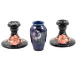 A pair of Moorcroft Pottery dwarf candlesticks, 'Oberon' pattern, and a small vase, 'Poppy' pattern.