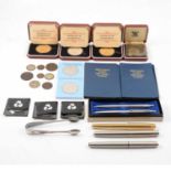 A collection of Commemorative coins and parker pens.