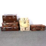 Seven vintage suitcases and bags, including two leather cases.