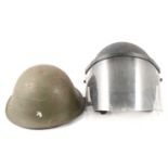 A collection of military helmets, hats, trench tool.