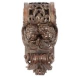 Carved wooden corbel with cherub masks