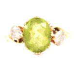 A peridot and diamond three stone ring.