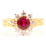 A ruby and diamond circular cluster ring.