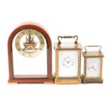 Two brass carriage clocks and a modern mantel clock.