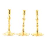 A pair of George II brass candlesticks, and another similar