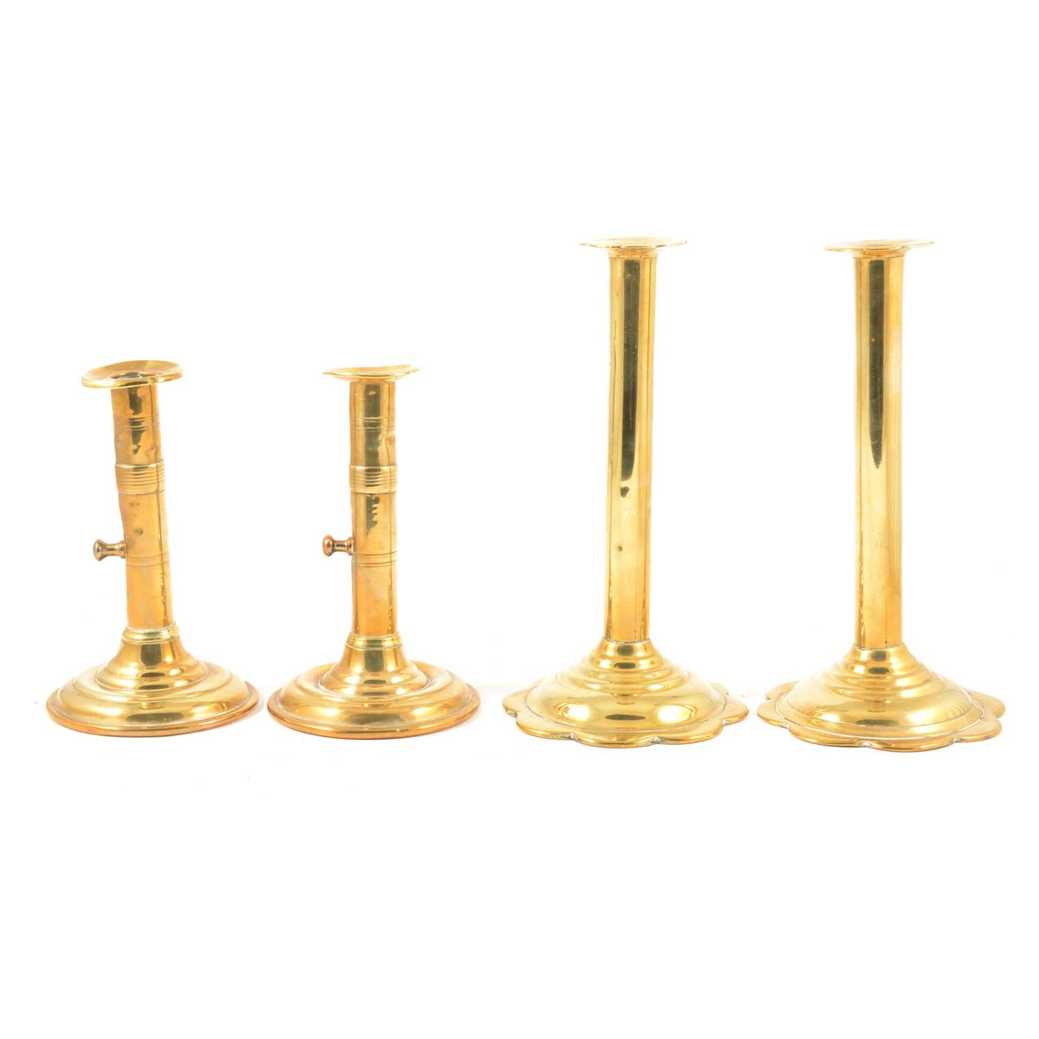 A pair of tall George III brass push-up candlesticks, and another pair