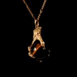 A tigers eye ball and claw 9 carat gold pendant and chain.