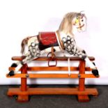 Victorian style rocking horse, carved and painted, on a pine trestle base, height 85cm overall.