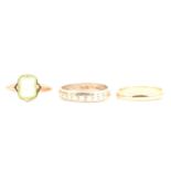 Two 9 carat gold wedding bands and a green stone solitaire ring.