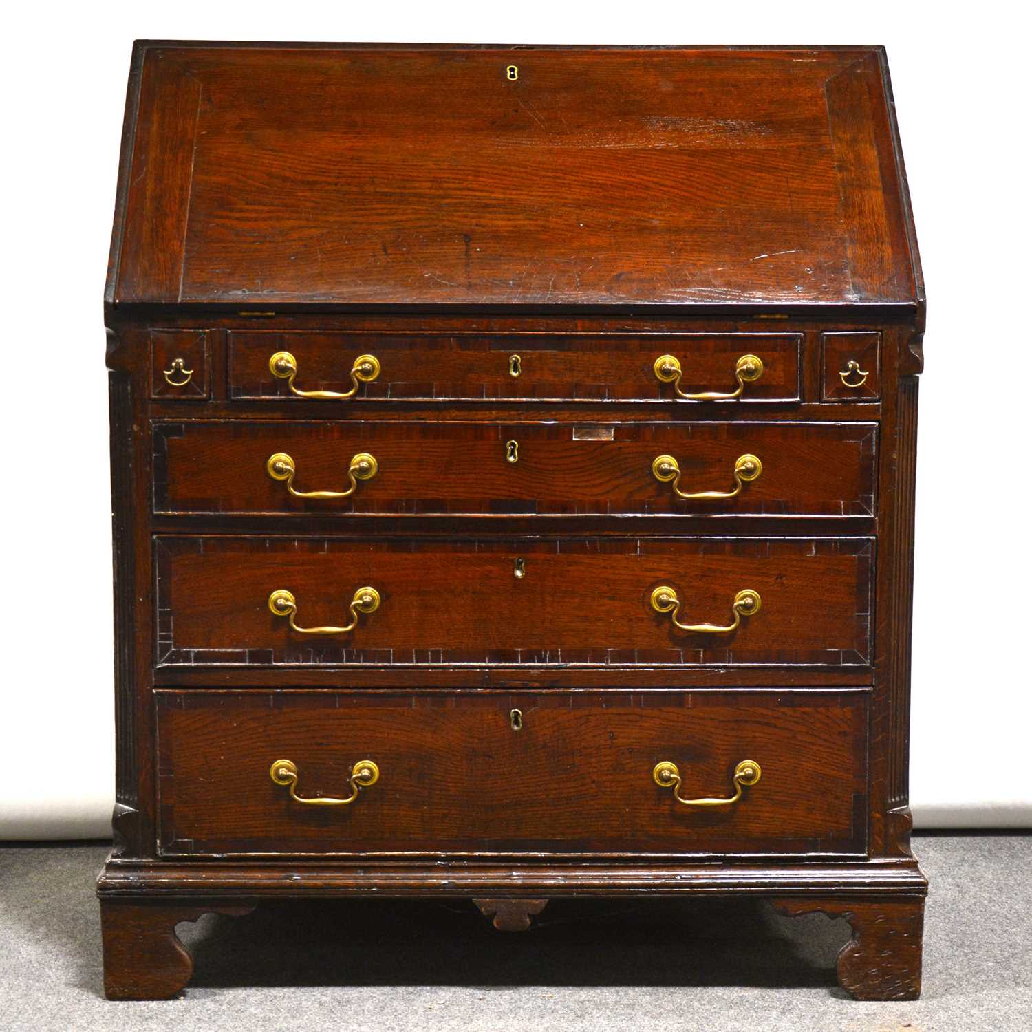 George III oak and mahogany bureau, fall front enclosing a well-fitted interior, with cupboard,