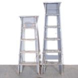 Two painted wooden step ladders.