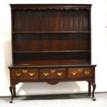 George III oak dresser, delft rack with cavetto cornice, shaped frieze, two fixed shelves with later