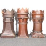 Two treacle glazed stoneware chimney pots, with castellated tops; and another similar, (damaged), (