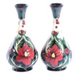 Moorcroft Pottery - a pair of Ruby pattern bottle vases.