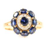 A blue stone and diamond cluster ring.