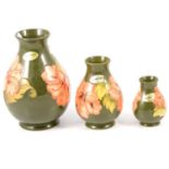 Moorcroft Pottery - three graduated Hibiscus pattern vases.
