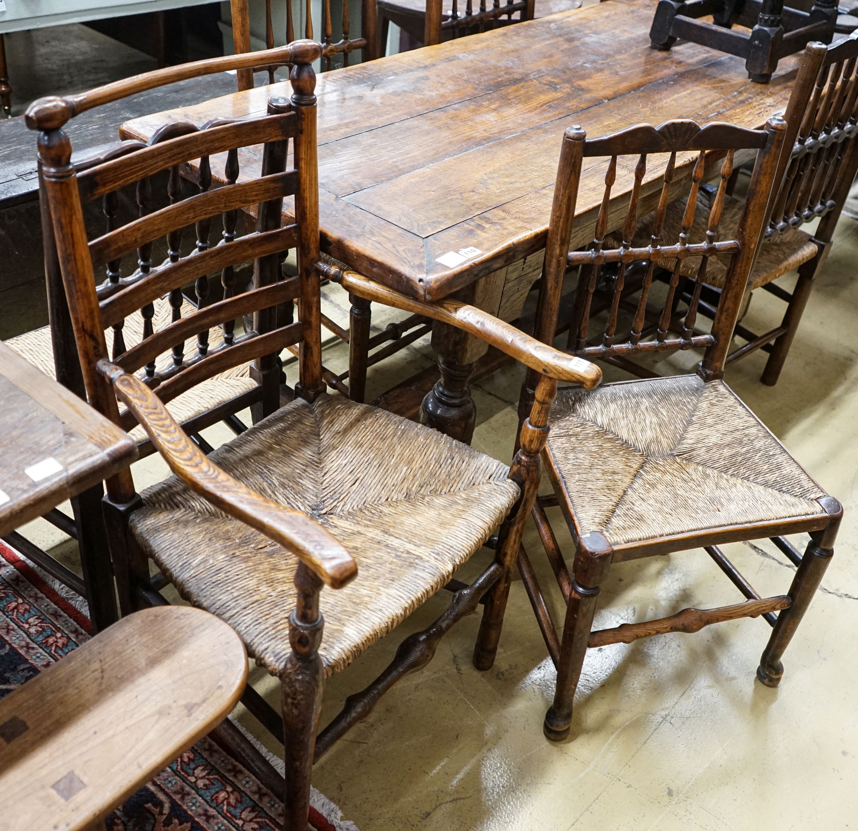 A harlequin set of five oak, elm and beech spindle back chairs, with rush seats and a similar