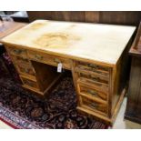A late Victorian figured walnut twin pedestal desk, fitted with nine drawers with decorative gilt