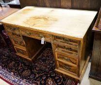 A late Victorian figured walnut twin pedestal desk, fitted with nine drawers with decorative gilt