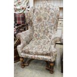 A William & Mary style walnut wing armchair, with flowering scroll upholstery and turned