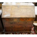 A George III oak bureau, with fitted interior, two short and three long drawers, width 92cm, depth