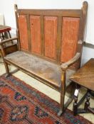 An early 19th century painted pine settle, with four panel back, scroll arms and solid seat, width