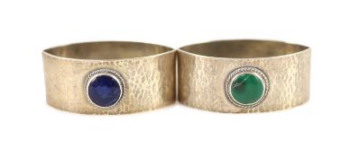 A pair of 1930's Liberty & Co planished silver navette shaped napkin rings, with inset cabochon