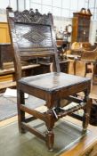 A 17th century oak back stool, with lozenge and foliate carved panelled back and solid seat, on