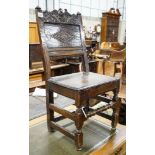 A 17th century oak back stool, with lozenge and foliate carved panelled back and solid seat, on