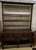 A mid 18th century oak dresser, with pierced cornice and three shelf rack over three drawers, with