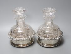 A pair of silver plated coasters with cut glass decanters. 20cm