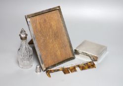 A silver mounted cigarette box, a silver mounted photograph frame, a silver thimble, a silver