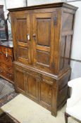 A 17th century style oak press cupboard, with three panelled doors, width 108cm, depth 50cm,