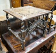 A 17th century style carved oak stool, with caned seat and H stretcher, width 47cm, depth 46cm,