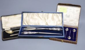 A cased set of six silver bean end coffee spoons, a cased silver spoon and pusher and a cased silver
