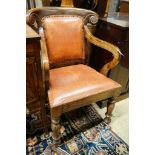 A pair of Victorian style hardwood elbow chairs with faded red leather upholstery, width 55cm, depth