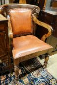 A pair of Victorian style hardwood elbow chairs with faded red leather upholstery, width 55cm, depth