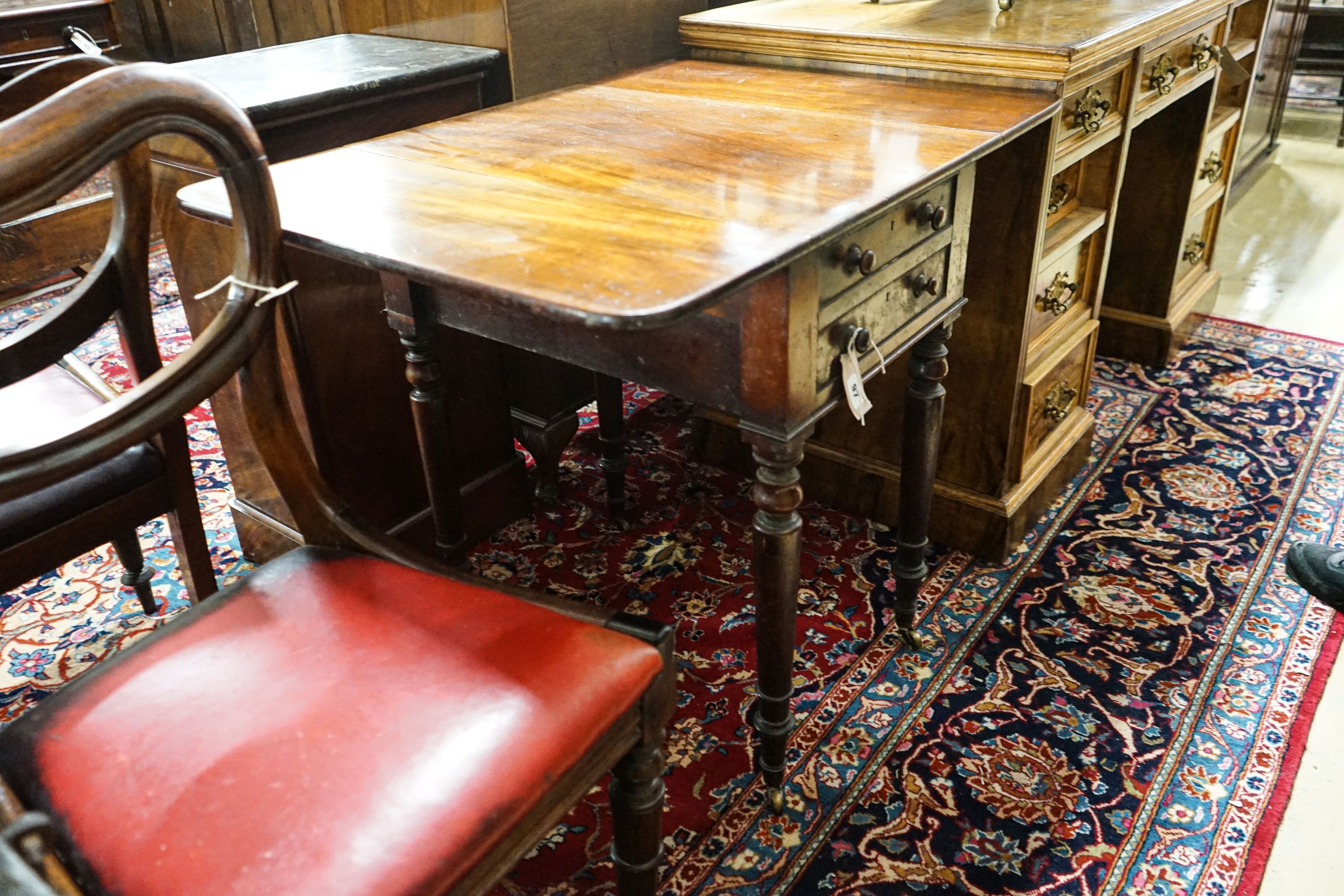 An early Victorian mahogany Pembroke work table, with twin flaps, two drawers, on turned legs and